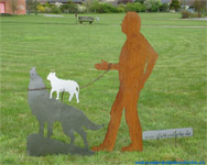 Installation-group silhouettes. The wolf-whisperer. Steel sheet rusty and blank wolf with upon spring steel superposed sheep and persons silhouette in life size.
